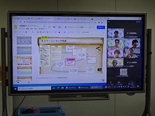 写真：大画面に映されたオンラインでのアイデアソンの様子