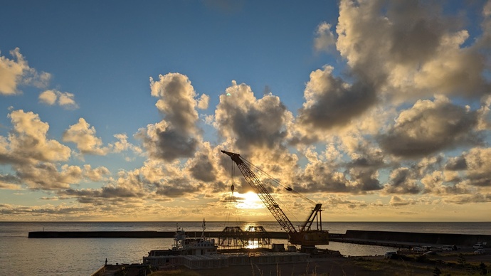 夕陽と雲と起重機船