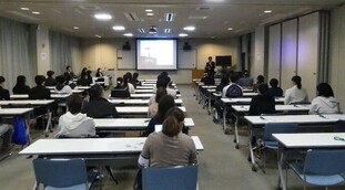 写真：県教育委員会による説明に耳を傾ける参加者